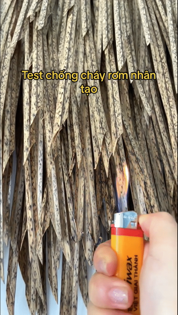 5 Ưu Điểm Khi Dùng Rơm Nhân Tạo Ở Làng Trong Thung 4 Ảnh minh họa quá trình thử nghiệm khả năng chống cháy của rơm nhân tạo bằng cách hơ lửa trực tiếp từ bật lửa vào vật liệu. Đây là một bước kiểm tra quan trọng để chứng minh tính an toàn, hạn chế cháy lan – một ưu điểm vượt trội so với rơm tự nhiên.