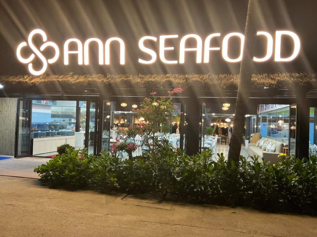 Top 3 Điểm Đặc Biệt Của Ann Seafood Restaurant Với Mái Rơm Nhân Tạo 3 Biển hiệu Ann Seafood phát sáng nổi bật ban đêm dưới mái rơm nhân tạo